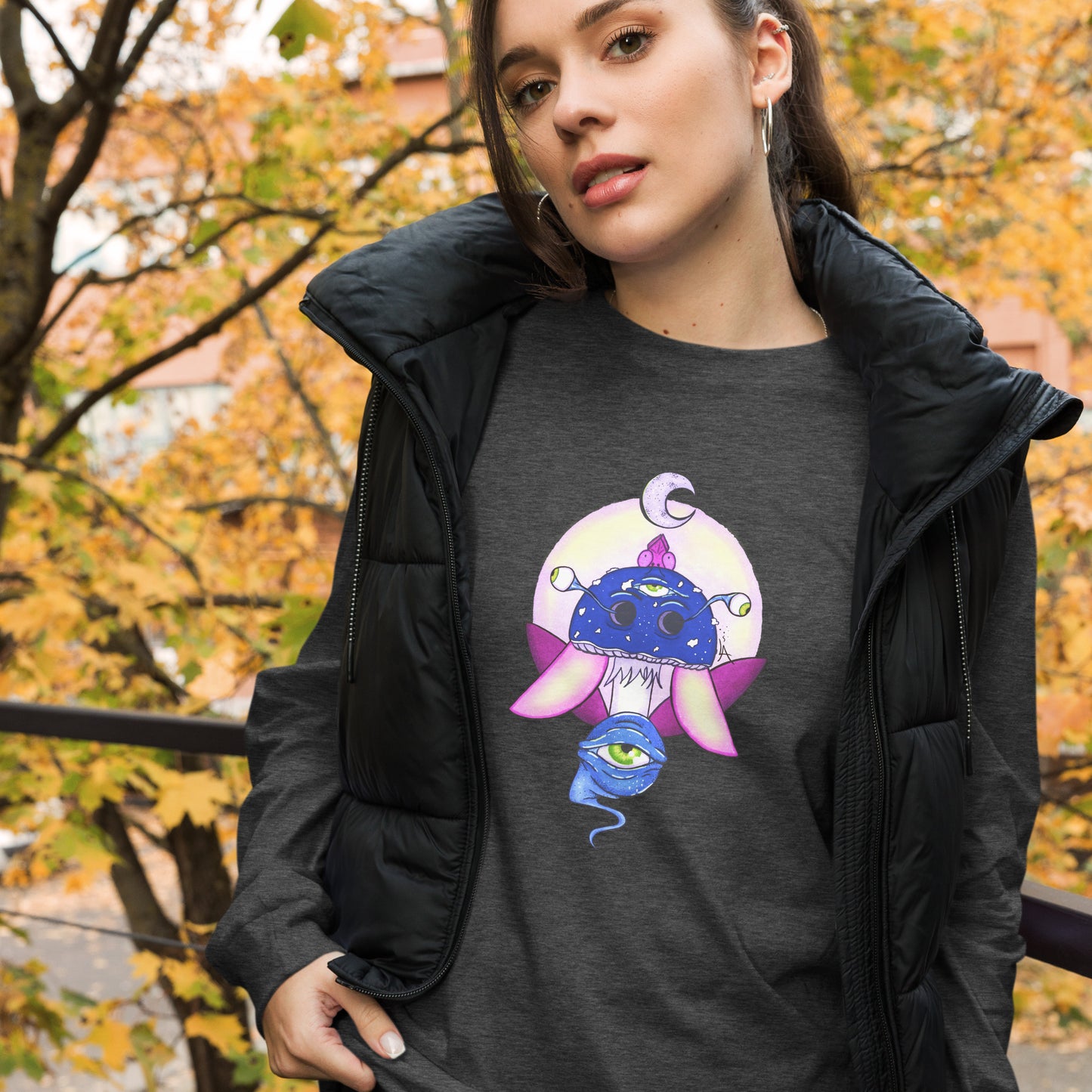 female wears dark grey heather long sleeve tee psychedelic toadstool mushroom with eyes full moon crescent moon flying insect in winter blue and purple