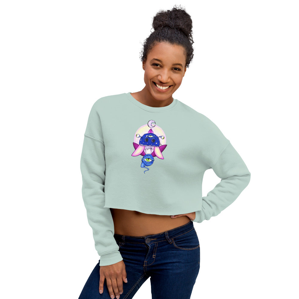 female wears dusty blue crop sweatshirt with psychedelic toadstool mushroom with eyes full moon crescent moon flying insect design in winter blue and purple